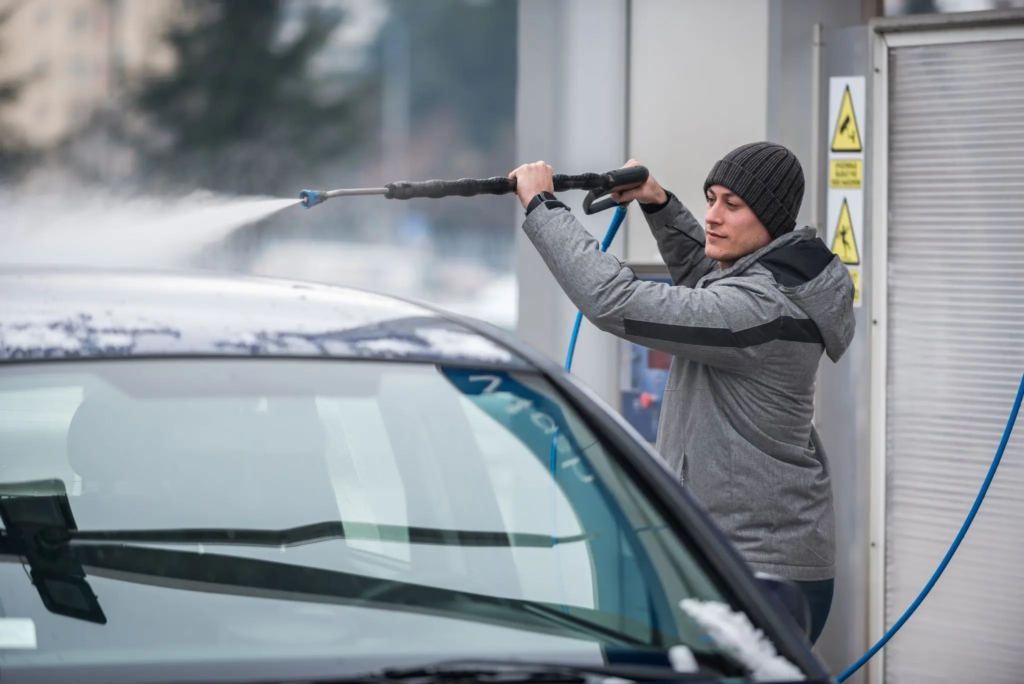 Person cleaning car during a winter morning.